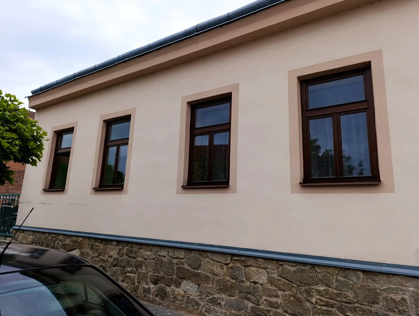 Nově natřená fasáda domu s hnědými okny