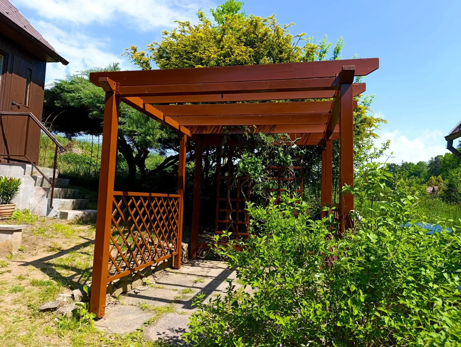 Natřená dřevěná pergola na zahradě